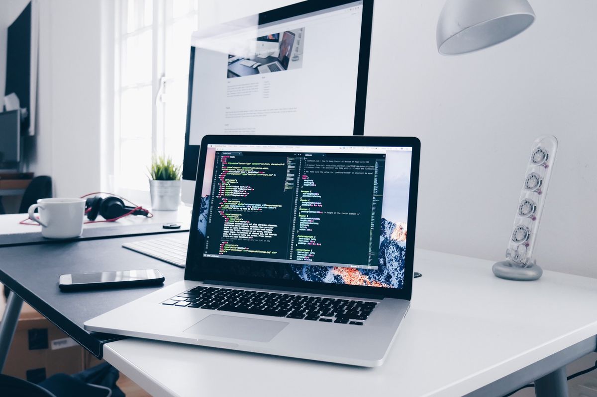 Coding on a MacBook in a bright home office setup, symbolizing the shift towards digital jobs.