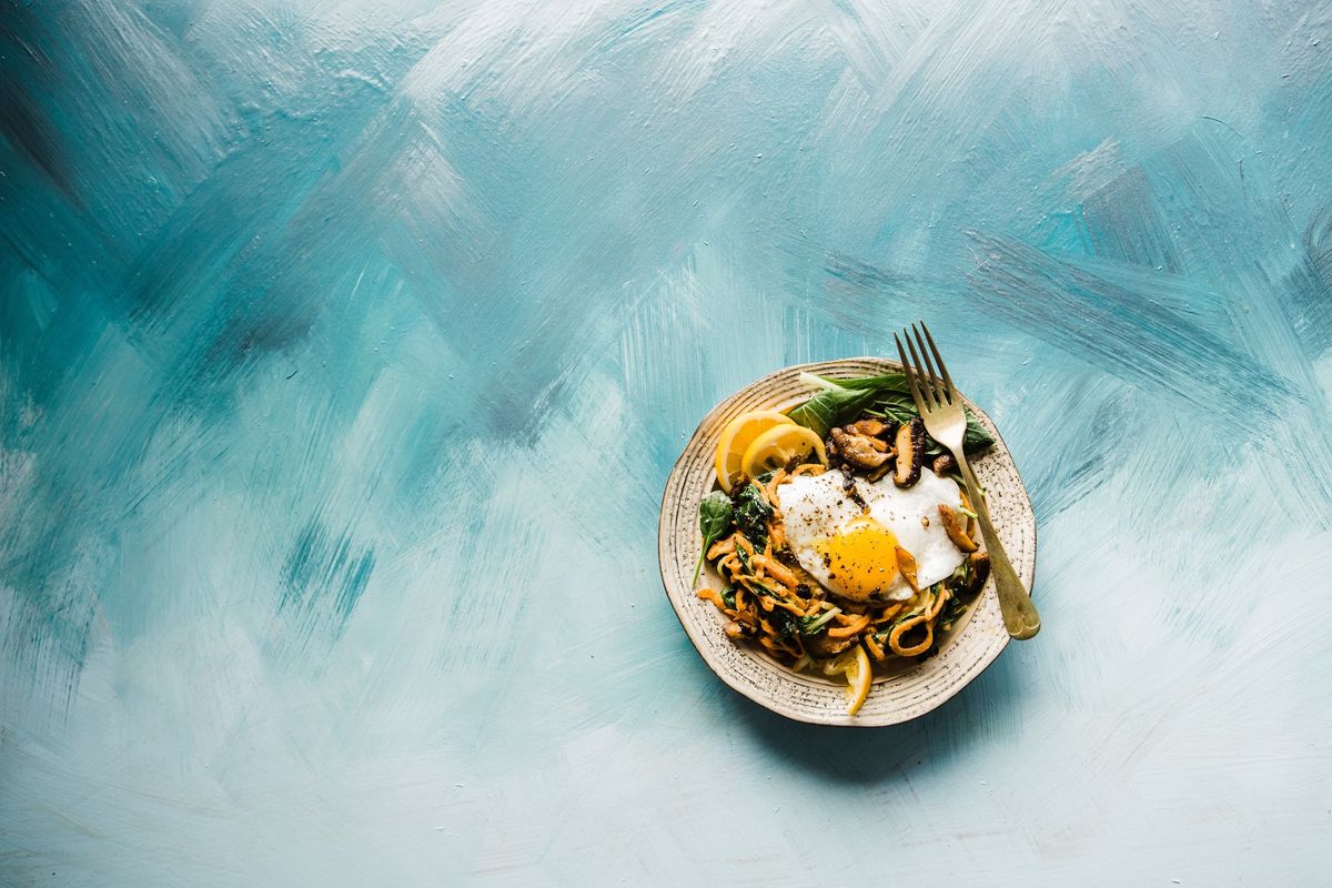 Fried egg atop a colorful keto stir-fry, symbolizing diet's impact on productivity.